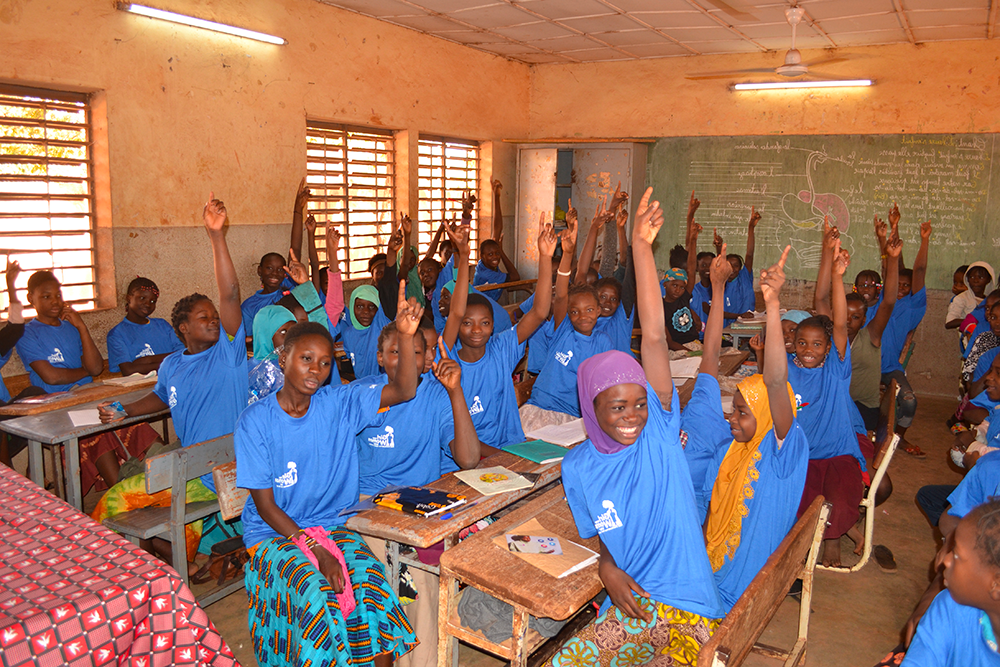 Girls in a Girl Now Woman Later at a menstruation workshop raising their hands in a discussion about menstrual cycles Nord-C in Burkina Faso, Africa.